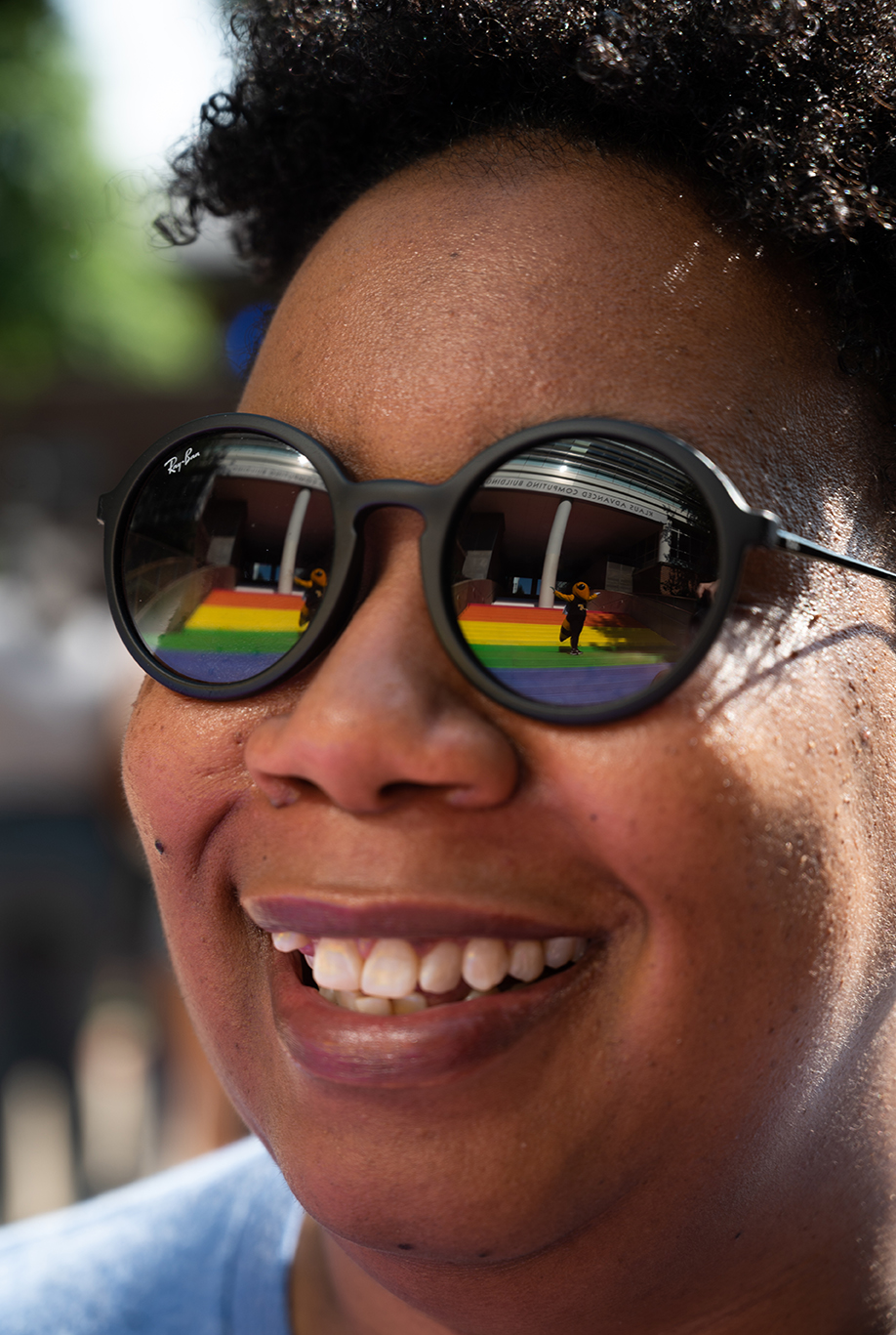 Buzz is reflected in Christen Steele’s glasses as she admires the Progress Pride Staircase at its grand opening in 2021. Photo by Allison Carter