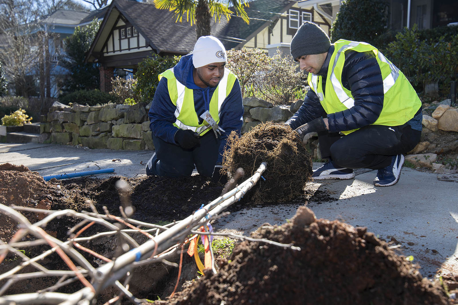 Javon Sloman Green (left) and Ayush Barmecha plant a tree in Midtown with Trees Atlanta.